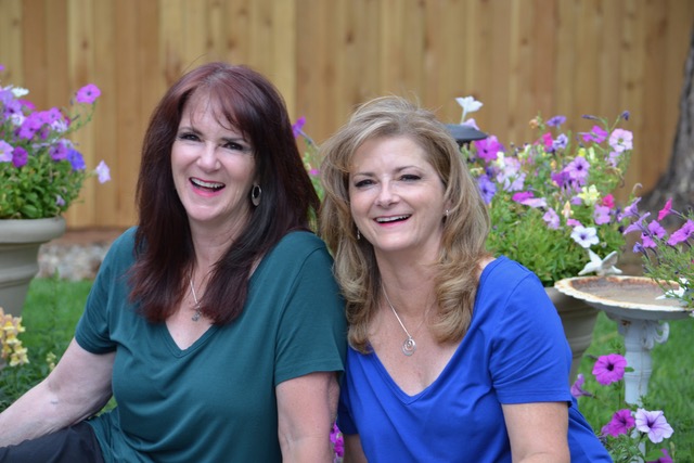 Beautiful and happy twin sisters laughing in a garden.